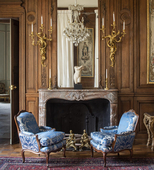 Chateau de Villette sumptuous historic estate chateau luxury accommodation exclusive rental France Paris luxurious library room Louis XV scones fireplace 18th century chairs blue silk brocade
